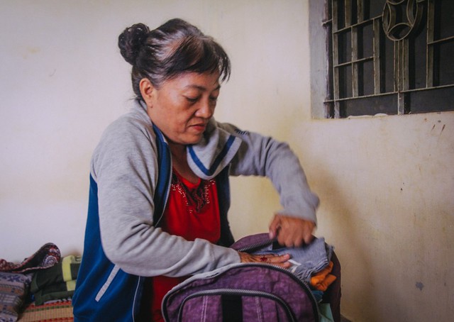 Bà Nhàn chuẩn bị quần áo để ra Huế đón con về Sài Gòn.