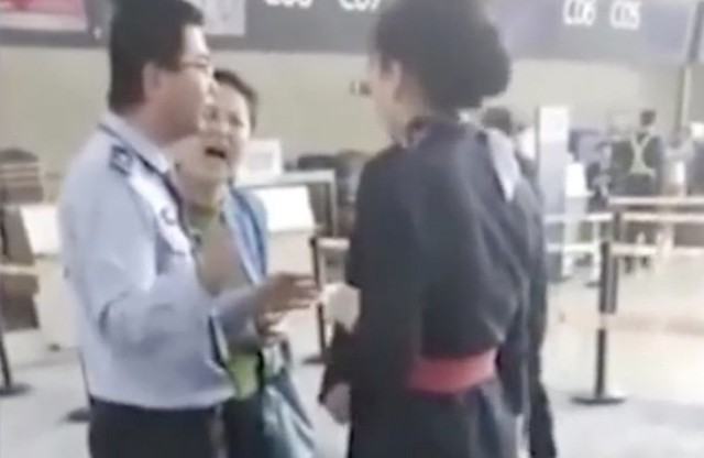 Nữ hành khách cãi nhau với nhân viên hàng không dù đã được cảnh sát can thiệp. Ảnh cắt từ video.