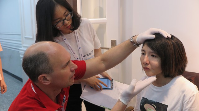Các bác sĩ của tổ chức Y tế thiện nguyện Vương quốc Anh (Facing The World) thăm khám cho một bệnh nhi nghèo mắc dị tật vùng mặt
