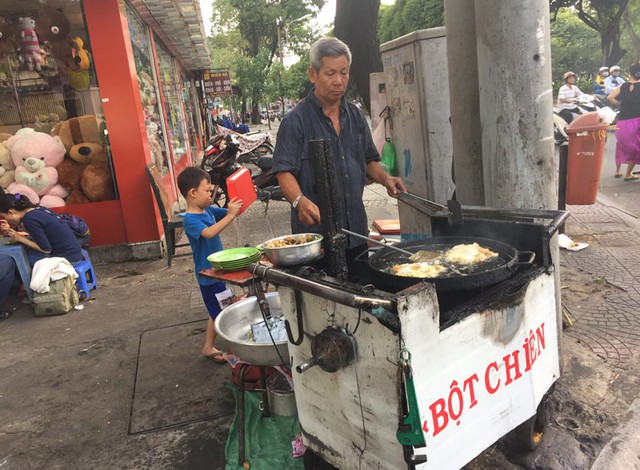 Tuấn đứng sau cầm khay chờ ông.