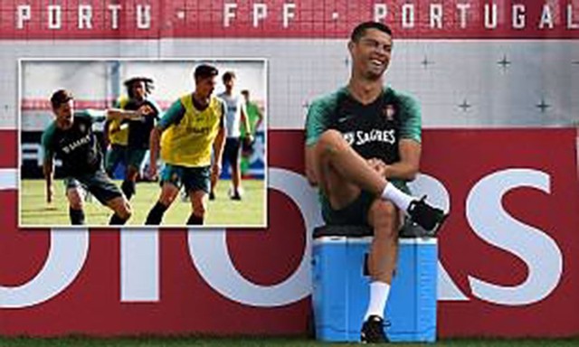 Ronaldo ngồi trên thùng nước đá vui cười nhìn đồng đội tập luyện.