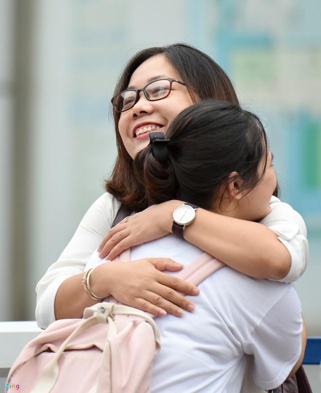 C&ocirc; đứng ở cổng trường, &ocirc;m từng học tr&ograve; trước giờ v&agrave; ch&uacute;c c&aacute;c con thi tốt.