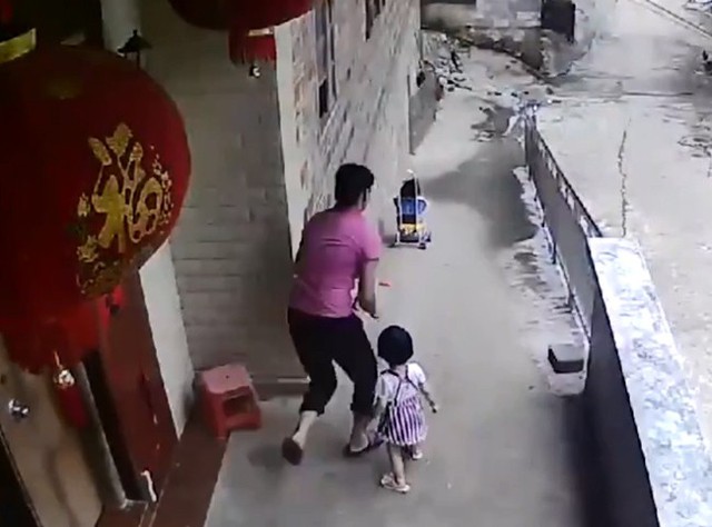 Người mẹ đuổi theo chiếc xe đẩy của con trai. Ảnh cắt từ video.