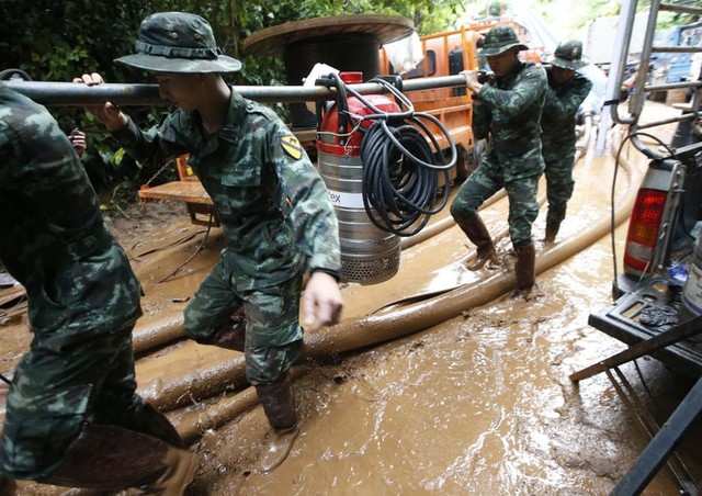 Binh sĩ mang thiết bị để tháo nước từ hang. Ảnh: AP.