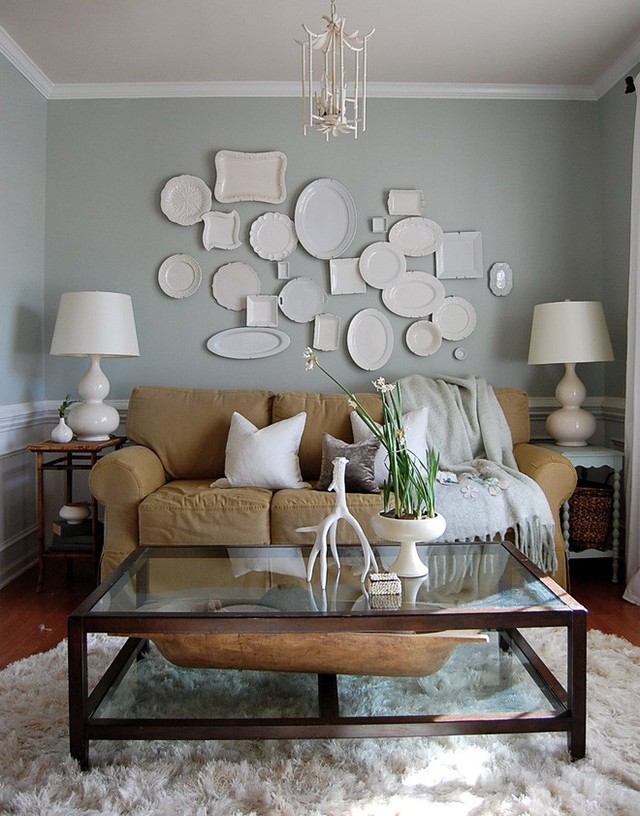 Những chiếc đĩa trắng với những hình dạng khác nhau được bài trí trên tường hài hòa với sắc trắng trong căn phòng khách.