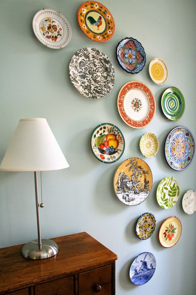 Những chiếc đĩa với hoa văn phong phú cùng màu sắc rực rỡ khác nhau được trang trí trên tường màu sáng.