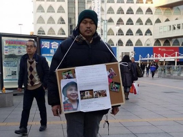 Anh Lê Anh Hào, cha của bé Nhật Linh, từng ròng rã nhiều ngày liền đứng ở những điểm đông người ở Nhật xin chữ ký để đưa hung thủ ra tòa sớm. - Ảnh: TTXVN