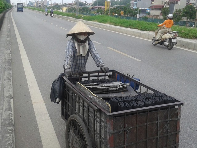 
Mỗi ngày, chị Phạm Thị Lý đẩy xe than hơn 50km để giao hàng và chào mời khách.     Ảnh: PV
