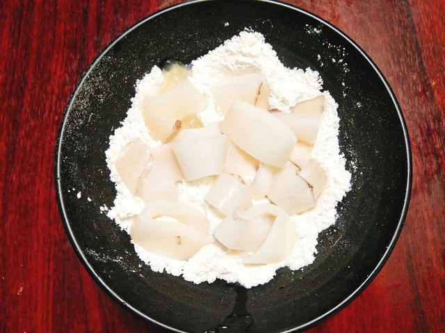 Bột bắp và bột mì cho vào bát tô, thêm 1/2 hỗn hợp muối tiêu vào cùng và trộn đều, chúng ta được phần bột khô để tẩm mực.