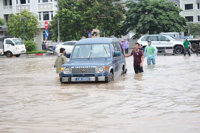 Ngoài việc thuê xe cứu hộ, nhiều chiếc ô tô thuê các nhóm thợ cơ động đẩy xe qua điểm ngập với giá là 10.000 đồng/ người.