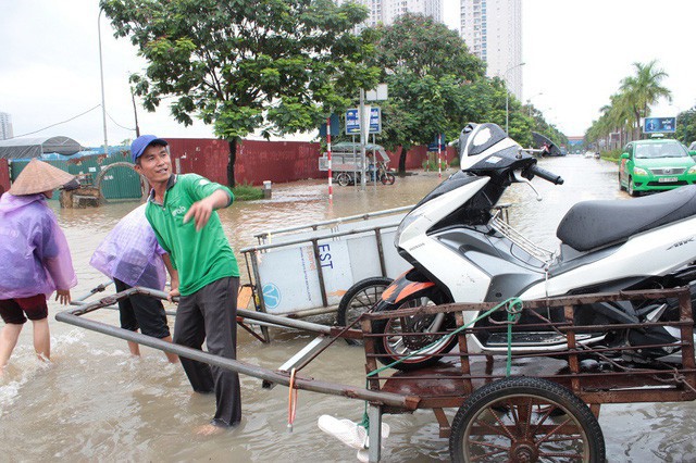 Theo ghi nhận của PV Dân trí, dịch vụ chở người qua điểm ngập ở đây khá đắt khách. Đoạn ngập kéo dài chỉ khoảng 100m nhưng có đến cả chục xe ba gác, xe cứu hộ xếp hàng “mời chào” khách qua điểm ngập.