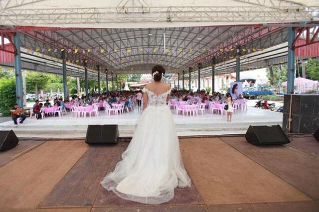 C&ocirc; d&acirc;u Jutathip diện v&aacute;y cưới, một m&igrave;nh l&ecirc;n s&acirc;n khấu xin lỗi kh&aacute;ch mời khi ch&uacute; rể kh&ocirc;ng xuất hiện ở đ&aacute;m cưới. Ảnh: Bangkok Post.