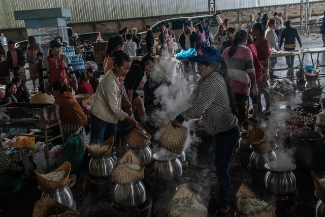 Các tình nguyện viên chuẩn bị cơm cho những người dân trú ẩn tại Paksong, Lào. Ảnh: Thời báo New York.
