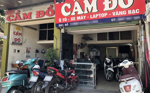 
Các tiệm cầm đồ chật ních xe máy, xếp tràn cả trên vỉa hè từ tay ga đến xe số, chưa kể vô số điện thoại và laptop trong tủ kính. Ảnh: Vietnamnet
