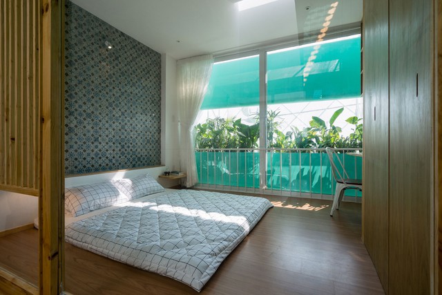 Cây xanh cùng những mảng kính dán giúp phòng ngủ không bị quá nắng.