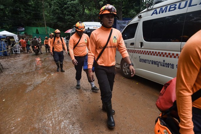Sáng ngày 8/7, chiến dịch giải cứu 12 thành viên đội bóng Thái Lan và một huấn luyện viên đã chính thức bắt đầu. Trong ảnh, công nhân tham gia phục vụ chiến dịch giải cứu di chuyển phía bên ngoài hang Tham Luang. Ảnh: AFP.
