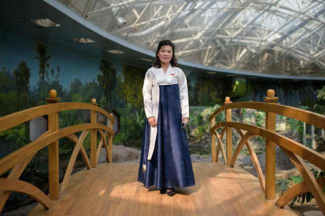 Hướng dẫn viên Kim Song-hui, 26 tuổi, chụp ảnh ngày 29/7 tại sở thú trung tâm ở Bình Nhưỡng. Cô Kim mặc một bộ hanbok trắng xanh đầy duyên dáng.