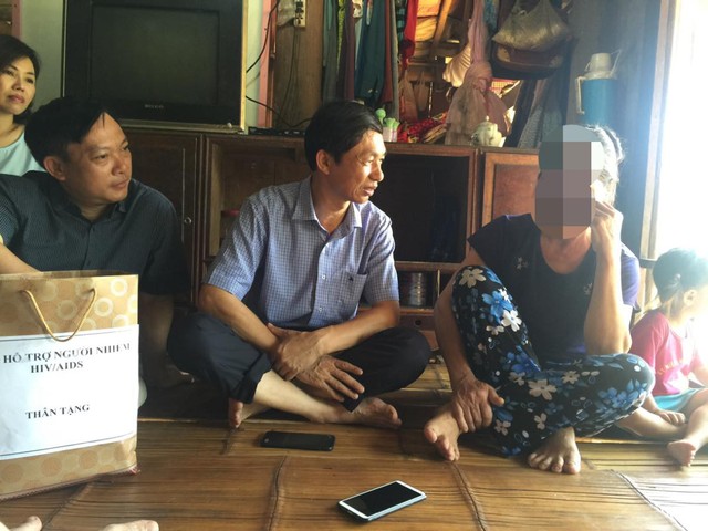 
TS Hoàng Đình Cảnh (bìa trái) thăm hỏi một người dân nhiễm H tại xã Kim Thượng, huyện Tân Sơn, Phú Thọ
