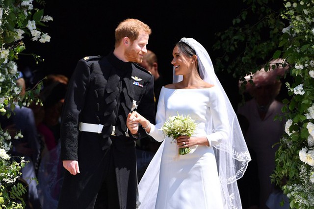 Meghan và Hoàng tử Harry đứng trước nhà nguyện St. Geoger sau khi hôn lễ hôm 19/5 kết thúc. Ảnh: UK Press.