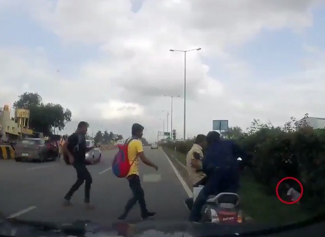 B&eacute; g&aacute;i b&ograve; dậy từ bụi c&acirc;y ven đường v&agrave; được người d&acirc;n cứu. Ảnh: Newslions.