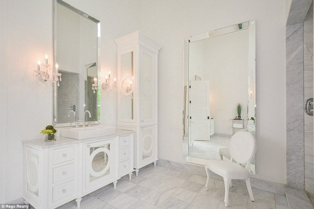 Một trong những phòng tắm được trang trí bằng chiếc bàn cẩm thạch và nội thất trắng.