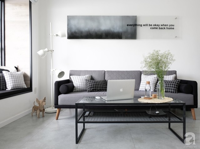 Góc không gian phòng khách được cải tạo khéo léo với ghế sofa văng, bàn trà bằng kính khung kim loại hiện đại.