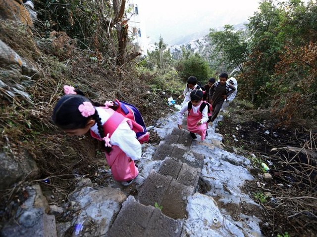 Trẻ em ở thị trấn Jazan, Ả-rập Xê-út leo lên những bậc thang bê tông được xây dựng trên sườn núi Fifa để đến trường.