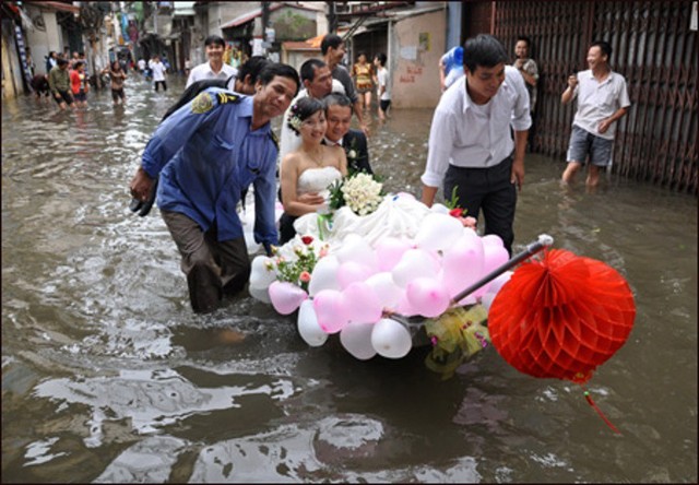 
Một đám cưới khác cũng trong trận lụt năm 2008 ở Hà Nội, cô dâu chú rể di chuyển bằng thuyền giữa phố ngập nước.  Ảnh: Internet
