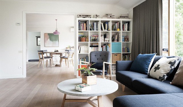 Bên trong ngôi nhà được thiết kế đơn giản với nội thất hiện đại. Sofa và bàn trà khung gỗ sồi chắc chắn giúp mặt bàn đá và ghế sofa bằng nệm nỉ màu xanh thêm nổi bật.
