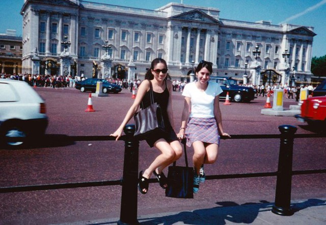 Meghan (váy đen), năm 15 tuổi, đi du lịch Anh với bạn thân Priddy và chụp ảnh kỷ niệm trước Điện Buckingham. Ảnh: Splash News.