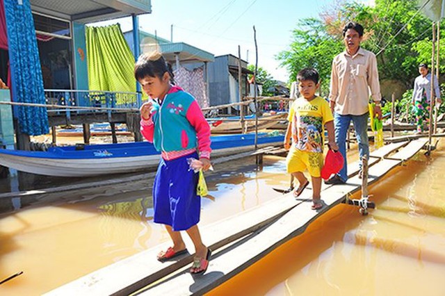 Học sinh đầu nguồn lũ An Giang đi học. Ảnh: Tiền Phong.