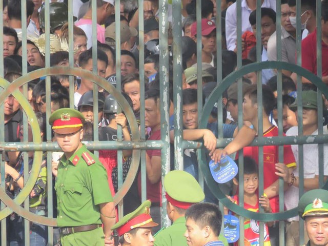 
Hàng trăm người đành đứng ngoài cổng hóng tin lễ hội qua điện thoại của người thân trong sân
