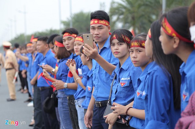 Hàng trăm sinh viên tình nguyện đứng hai bên đường Võ Nguyên Giáp cùng lực lượng cảnh sát đảm bảo an ninh trật tự. Ảnh: Zing.vn