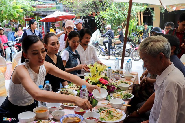 Tiểu Vy ngồi cạnh bố mẹ và ông nội, cùng đại diện ban tổ chức (BTC) cuộc thi Hoa hậu Việt Nam 2018. Cô ân cần lấy thức ăn cho ông nội. Bữa tiệc gồm các món đơn giản theo truyền thống của người Hội An.