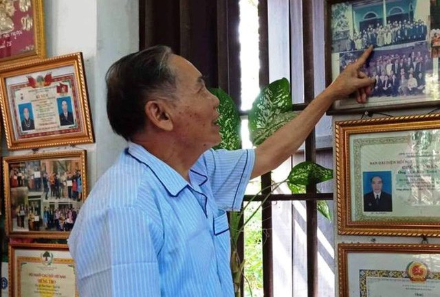 Thầy giáo chủ nhiệm cấp 3 của Chủ tịch nước Trần Đại Quang nhìn những bức hình thầy trò chụp chung năm xưa.