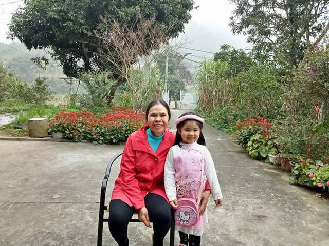 Bà Nguyễn Thị Phương chụp ảnh cùng cháu ngoại bên vườn hoa