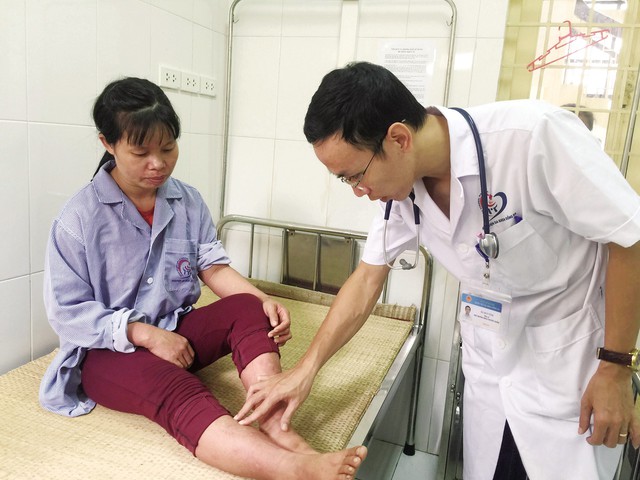
Bác sĩ K hoa Truyền nhiễm (BVĐK Đống Đa) kiểm tra tình trạng phát ban sốt xuất huyết của bệnh nhân Hoàng Thị Dung. Ảnh: T.Nguyên
