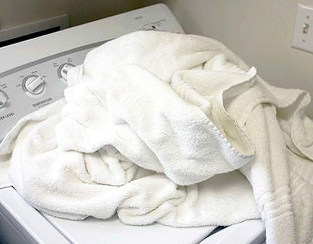 Bỏ khăn vào máy giặt, và để máy giặt ở chế độ nước nóng. Bỏ 1 chén giấm trắng vào và khởi động máy giặt.