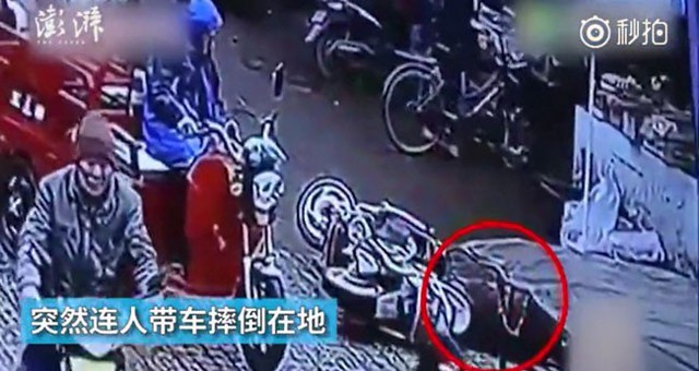 Người l&aacute;i xe ba g&aacute;c đứng ngay b&ecirc;n cạnh chỉ thờ ơ nh&igrave;n.