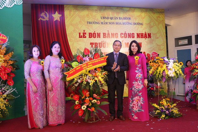 Đc Nguyễn Quang Trung - Ủy viên ban thường vụ - Phó chủ tịch UBND Quận Ba Đình tặng hoa chúc mừng nhà trường