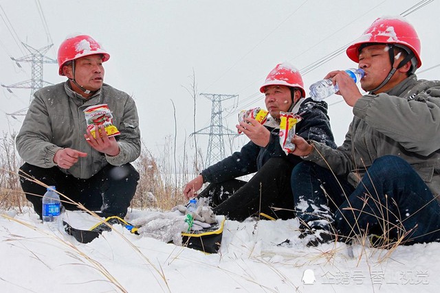 3 nhân viên ngành điện ở tỉnh Hà Nam phải cuốc bộ 30 cây số để thực hiện việc kiểm tra đường dây giữa lúc tuyết rơi nặng. Buổi trưa, họ phải ăn mì tôm sống và uống nước lọc. Ảnh: QQ.