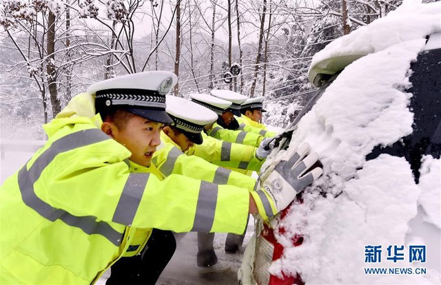 Nhiều phương tiện cá nhân gặp trục trặc trên đường vì tuyết rơi dày, phải nhờ đến sự trợ giúp của lực lượng công an. Đây là hình ảnh không hiếm gặp trong mùa đông ở Trung Quốc. Ảnh: Xinhua.