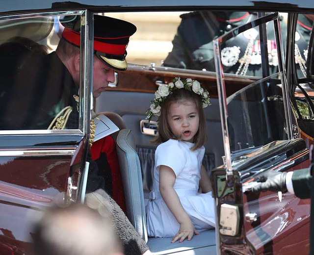 Công chúa nhỏ chu môi trò chuyện khi bước xuống xe sau khi rời Lâu đài Windsor, trong khi bố William giữ cửa cho cô bé bước ra ngoài.