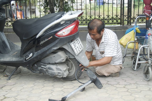 
Dù bị cưa cụt hai chân nhưng ông Mị vẫn luôn lạc quan, mưu sinh bằng nghề sửa xe máy, xe đạp. Ảnh: Vũ Đồng
