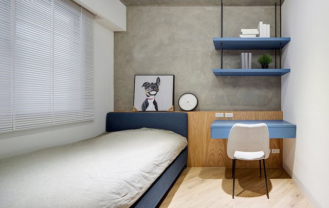 
Góc phòng ngủ nhỏ được thiết kế khéo léo với giường màu xanh xám cùng tông với bàn học xinh xắn.
