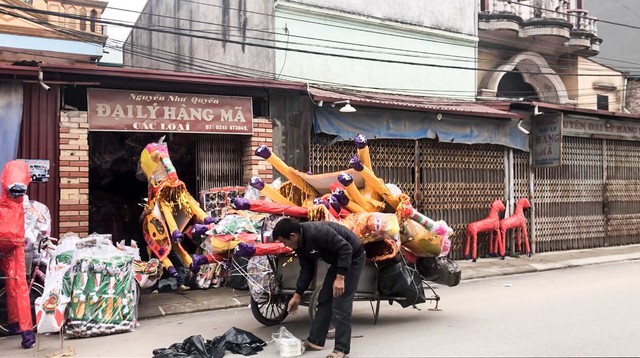 Trên khắp các con đường làng Đông Hồ, người dân chuyển vàng mã ra các điểm tập kết bằng nhiều phương tiện: xe máy, xe ba gác, xe tải cỡ nhỏ, xe bò…
