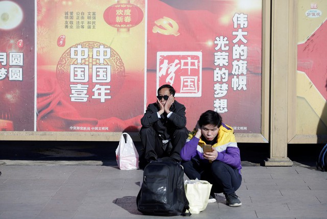 Hành khách ngồi chờ bên ngoài nhà ga Bắc Kinh, tàu hỏa vẫn là phương tiện di chuyển chủ yếu của người Trung Quốc trong dịp Tết. Ảnh: Reuters.
