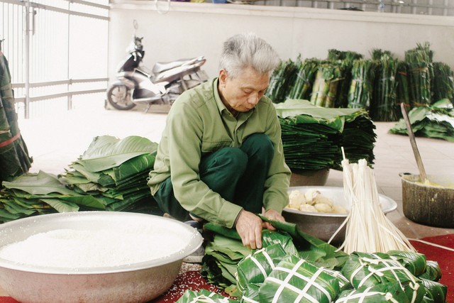 
Ông Phạm Văn Bảy (72 tuổi, ở thôn Tranh Khúc) cần mẫn gói từng chiếc bánh chưng. Ảnh: Huyền Trang
