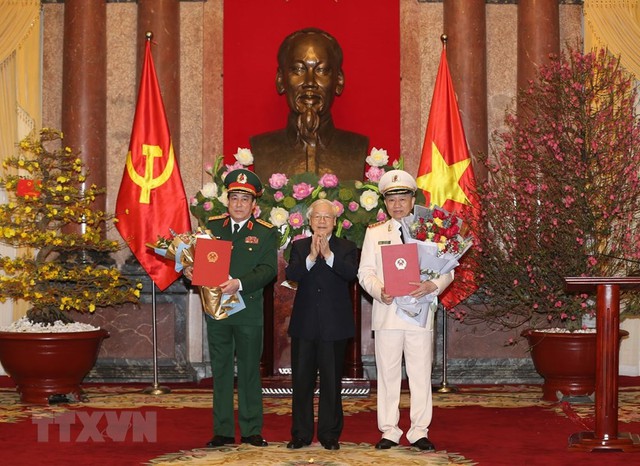 Tổng Bí thư, Chủ tịch nước Nguyễn Phú Trọng trao quyết định phong quân hàm Đại tướng và tặng hoa chúc mừng ông Tô Lâm, Lương Cường. Ảnh TTXVN