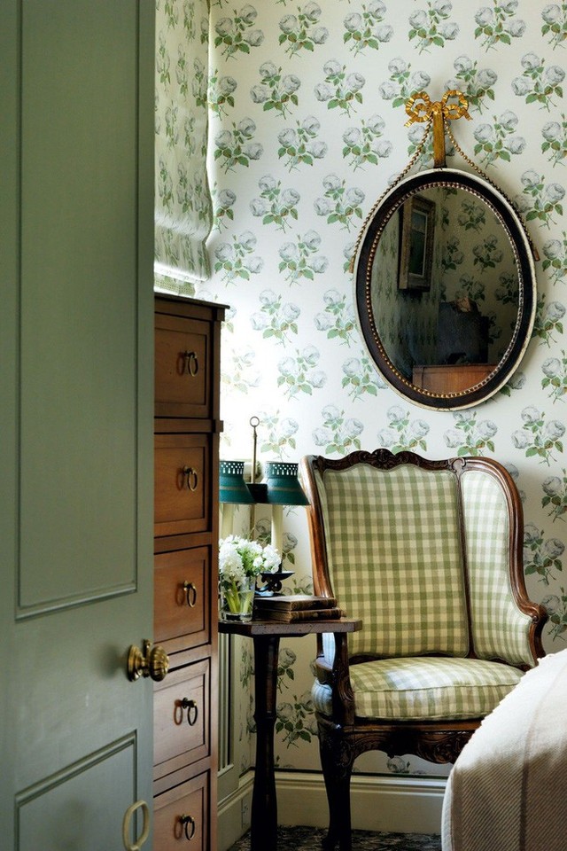 
Hình nền in hoa và một chiếc ghế bọc vải kẻ sọc trông hài hòa trong nhà tranh kiểu Anh.
